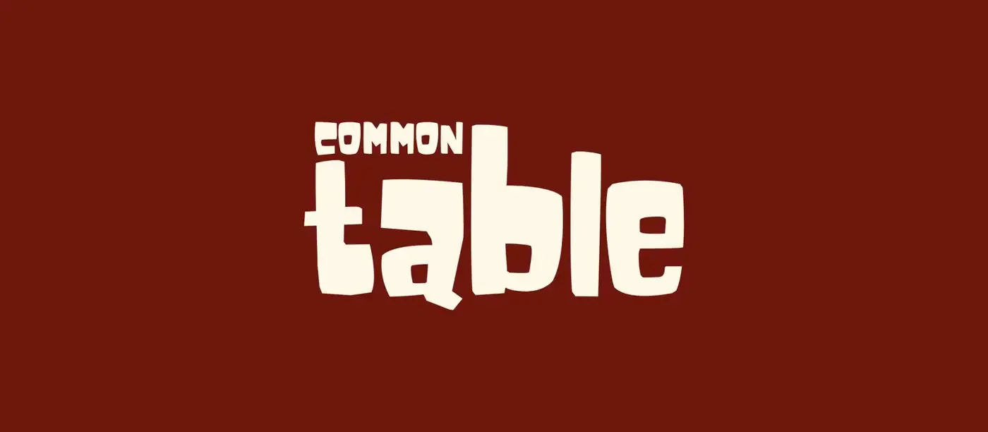 Common Table wordmark in warm cream on deep burgundy