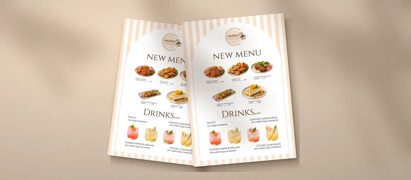 Two printed Madras Chronicle new menus on a warm table with soft leaf shadows