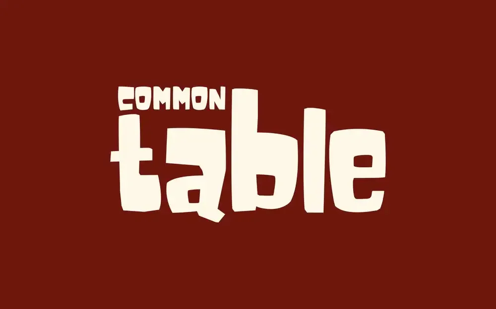 Common Table wordmark in cream on burgundy