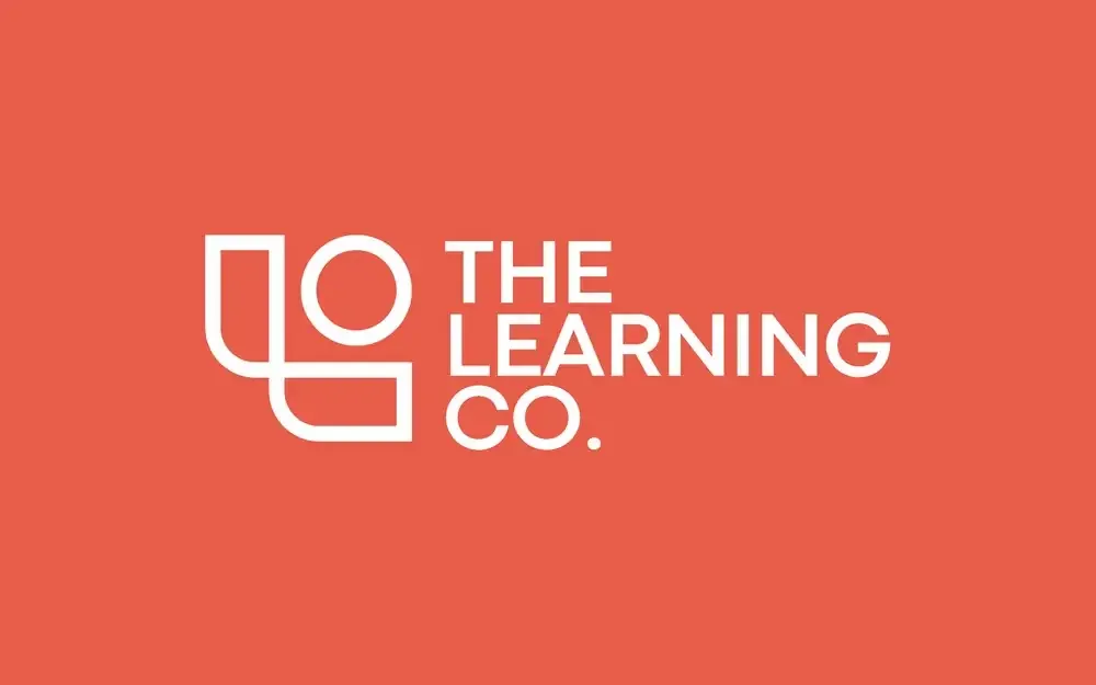 The Learning Co. logo reversed in white on coral